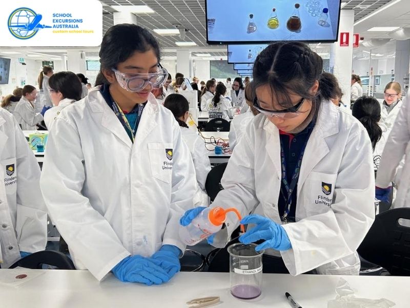 Students performing hands on chemistry experiments in a university lab as part of a STEM learning excursion in Melbourne